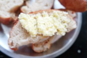 Spreading the cheese mix on garlic bread